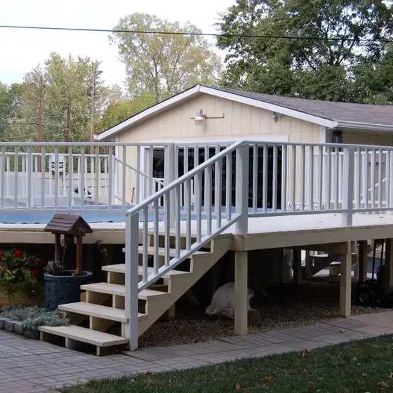 White-railed deck with new stairs built off the back of a house