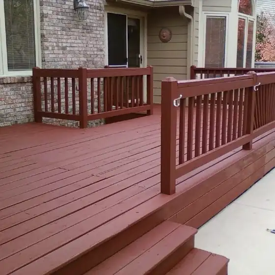 Deck steps and railings finished in a red-brown stain beside a pool cover