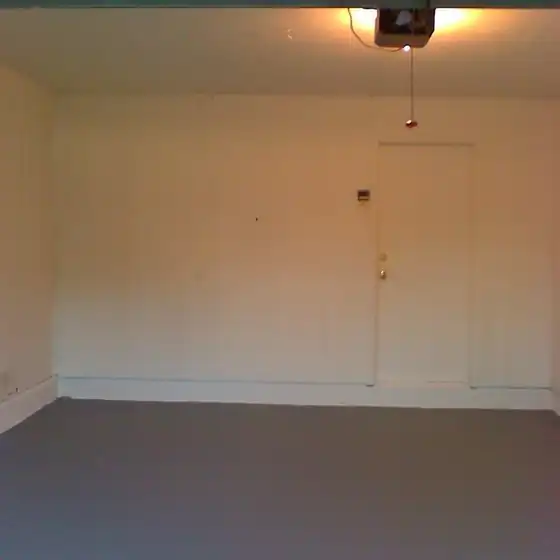 Empty finished garage with painted walls and a coated grey floor
