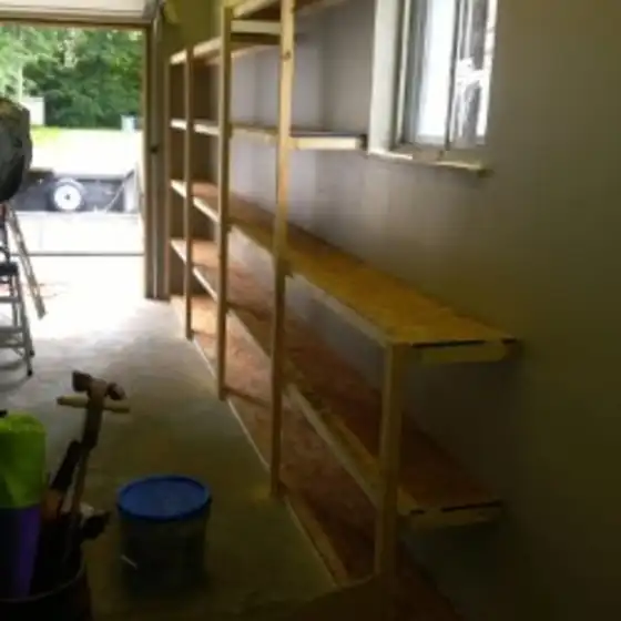 Garage wall framed out with new wood shelving under a window