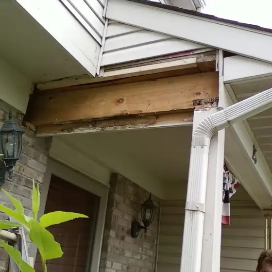New board fitted into a porch header after rotted wood was cut out, below the roofline